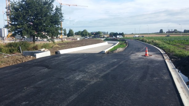 Links het betonnen fietspad dat leidt naar de tunnel